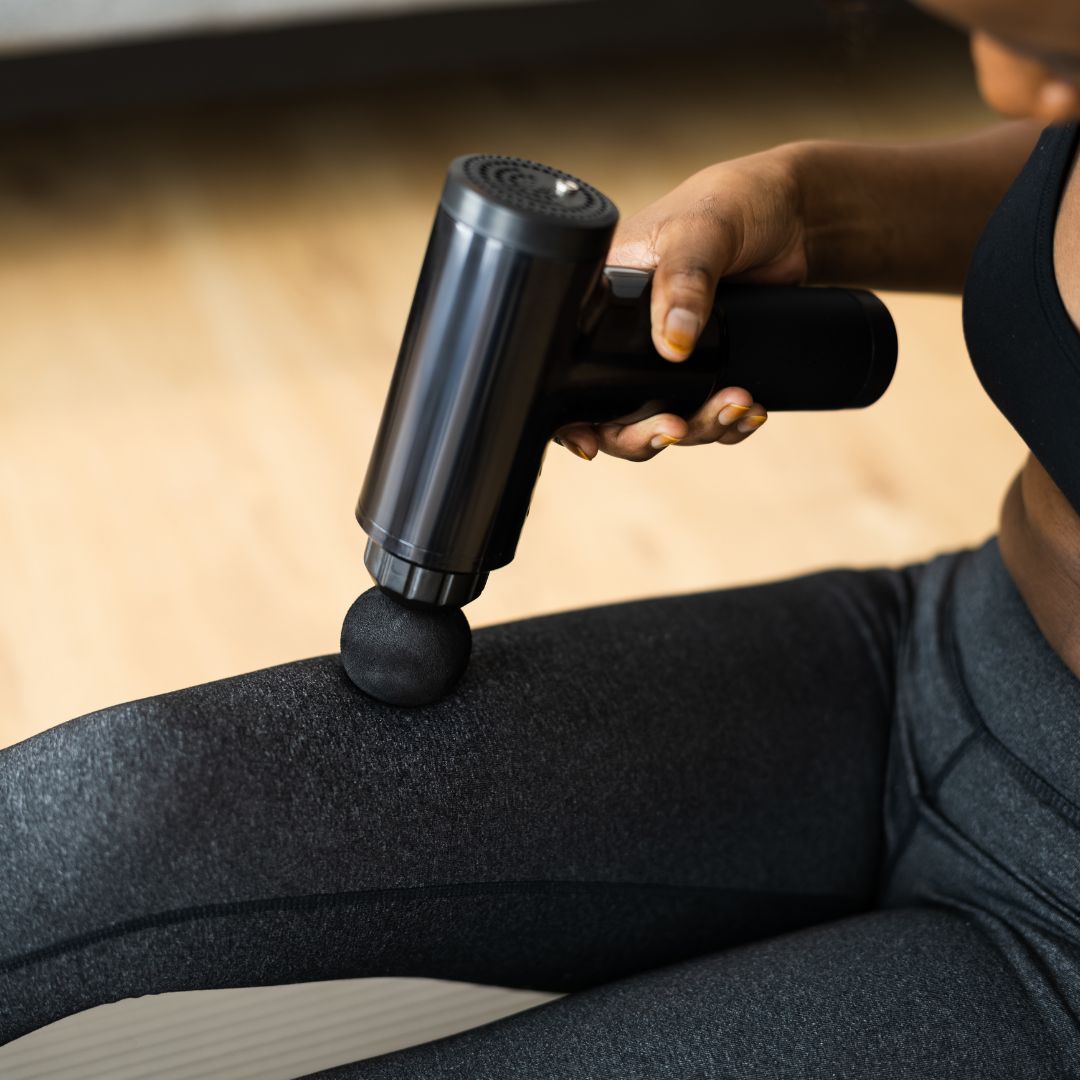 person using massage gun for muscle recovery