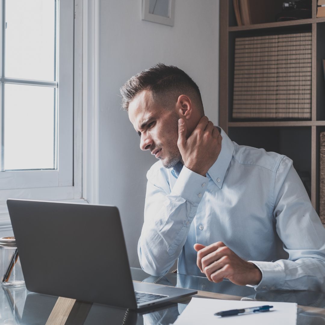 man holding his neck in an office