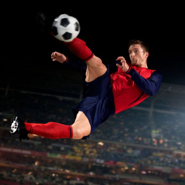 athlete kicking soccer ball