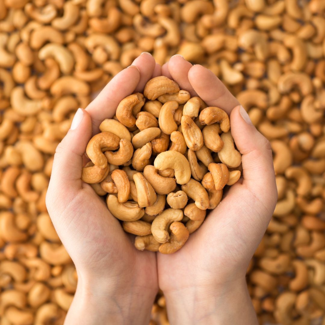 Person holding a handful of cashews. 