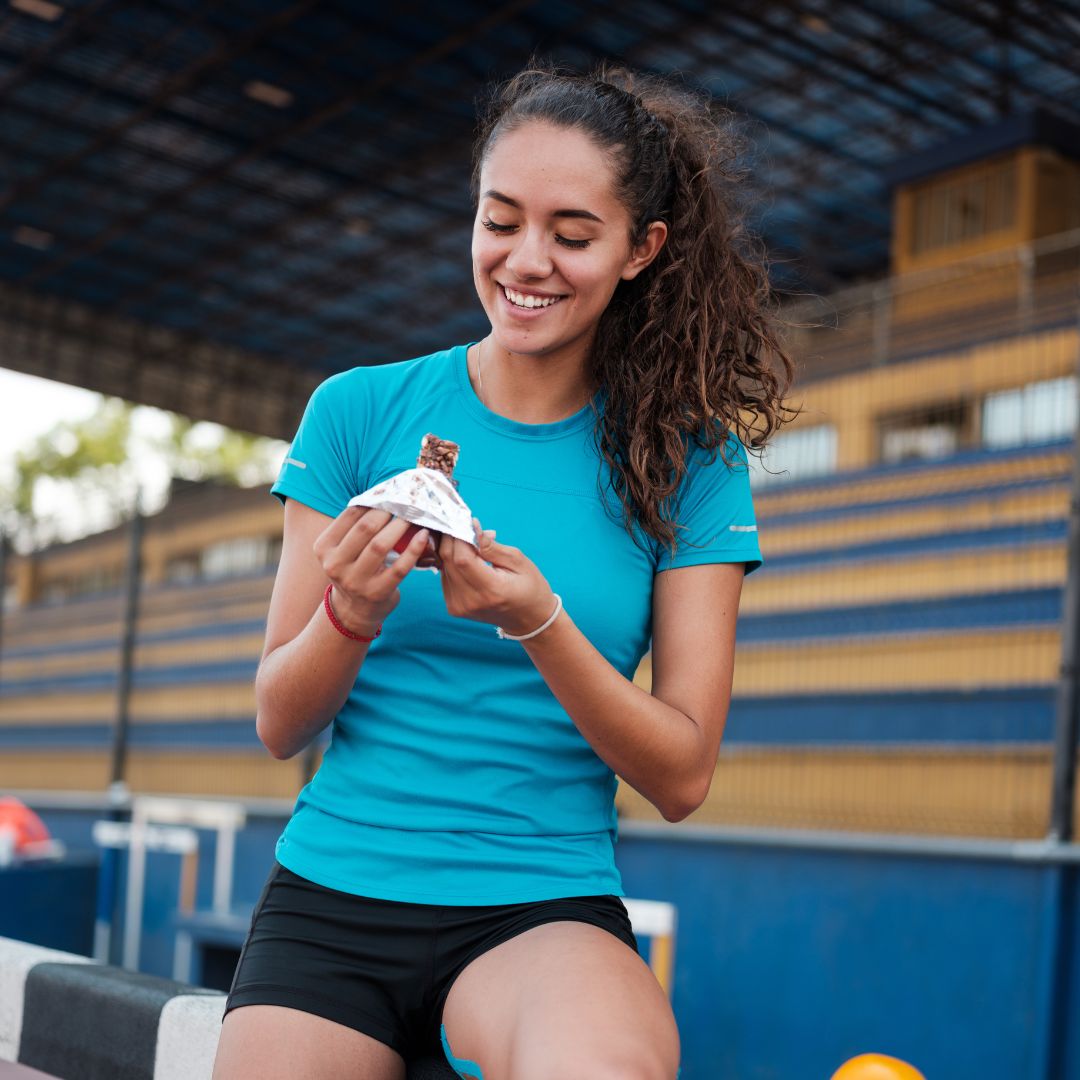 Woman eating a protein bar. 