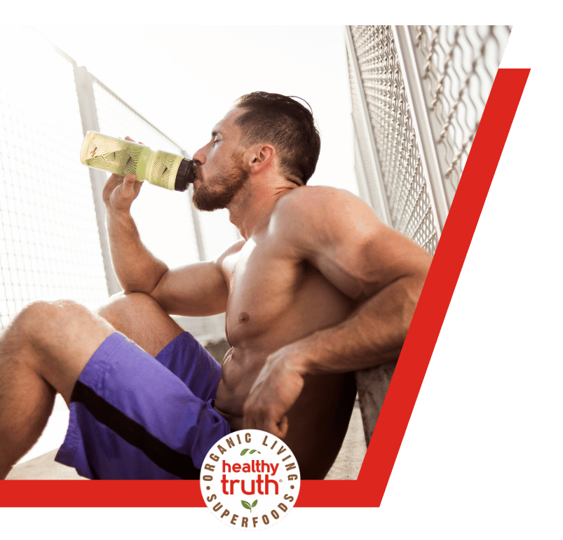 man drinks from a bottle recovering from workout