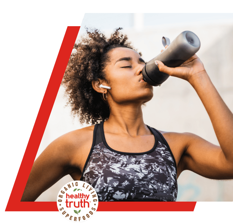 woman drinks from a bottle during workout